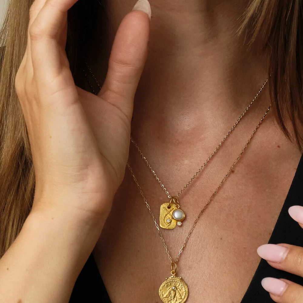 Sea Pendant | 24k gold pendant on a model, styled with Mahi and Ephesus pendants